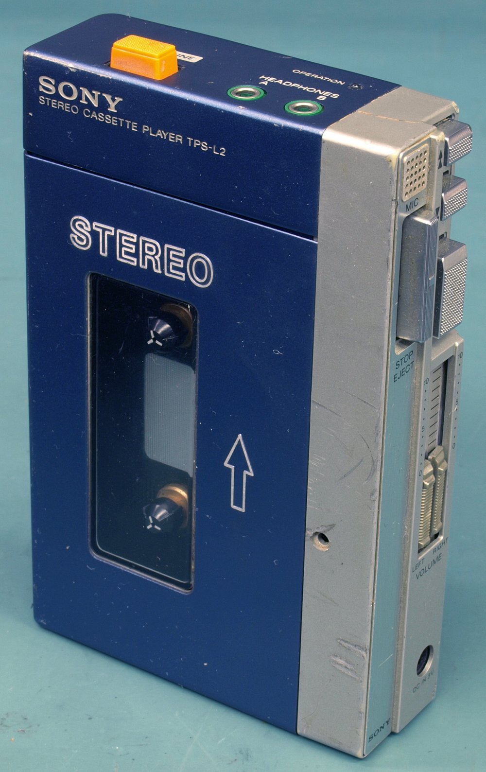 The original Sony Walkman TPS-L2 from 1979, a blue and silver portable cassette player with orange buttons, photographed against a white background